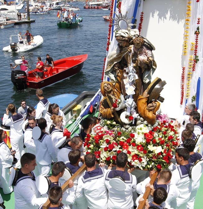 Los marineros porteadores llevan a la Virgen del Carmen hasta el altar instalado en el barco para la procesión. Foto Diario de Arousa.